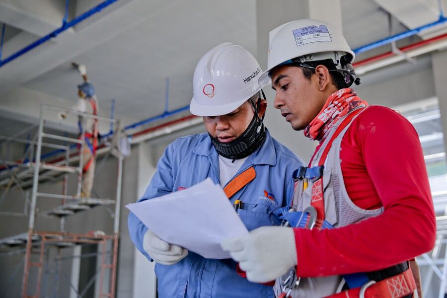 Jefes de obra revisando planos en una reforma de vivienda